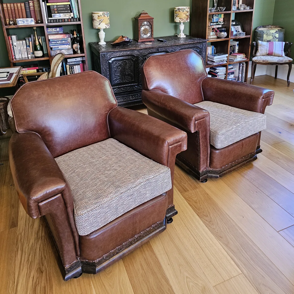 A pair of restored brown leather club armchairs with herringbone tweed seat cushions