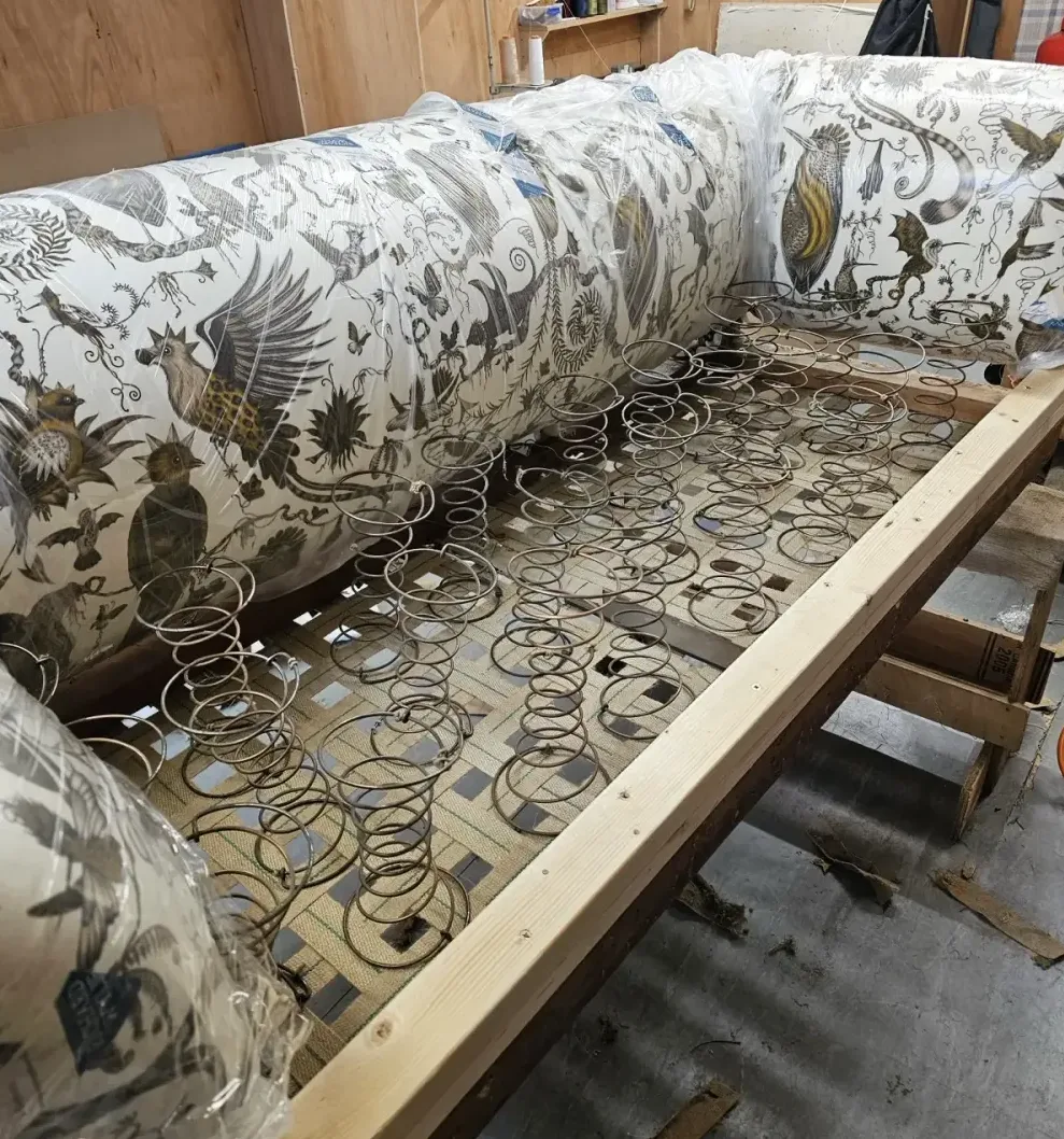 A sofa being restored by hand