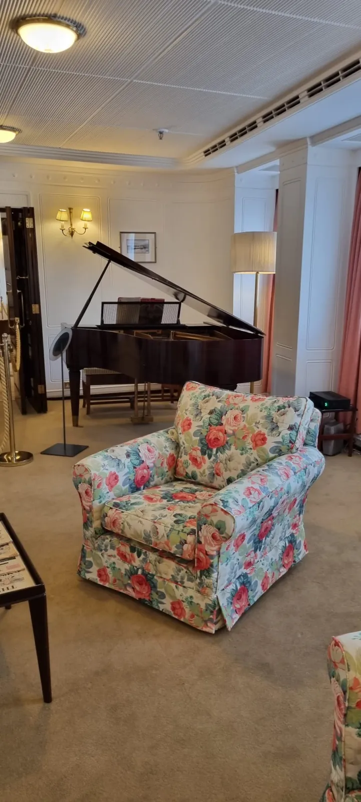 Reupholstered floral rose-print armchair beside the grand piano aboard the Royal Yacht Britannia