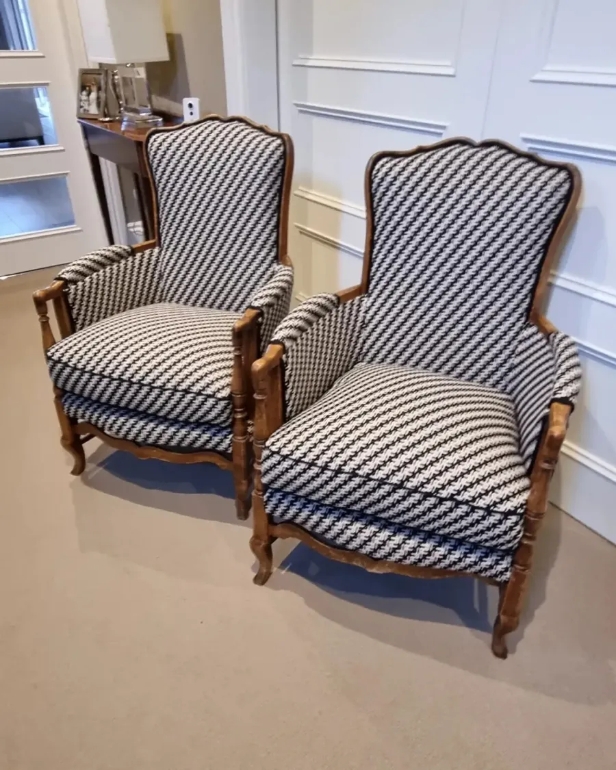 A pair of French bergère armchairs reupholstered in a black-and-white houndstooth weave
