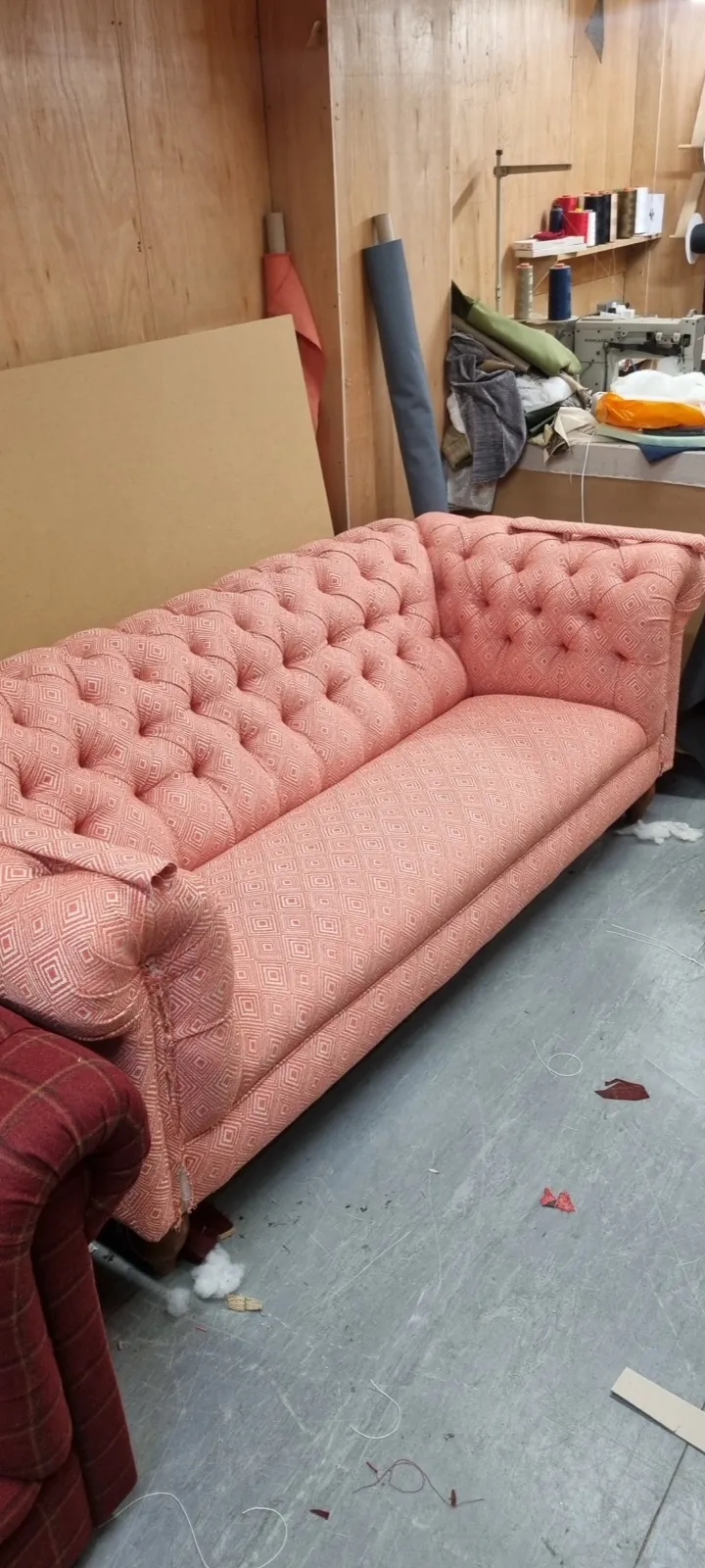 Pink diamond-patterned deep-buttoned sofa in the workshop
