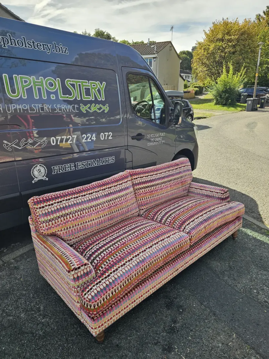 Sofa reupholstered in a multicoloured spotted stripe weave, beside the Absolute Upholstery van